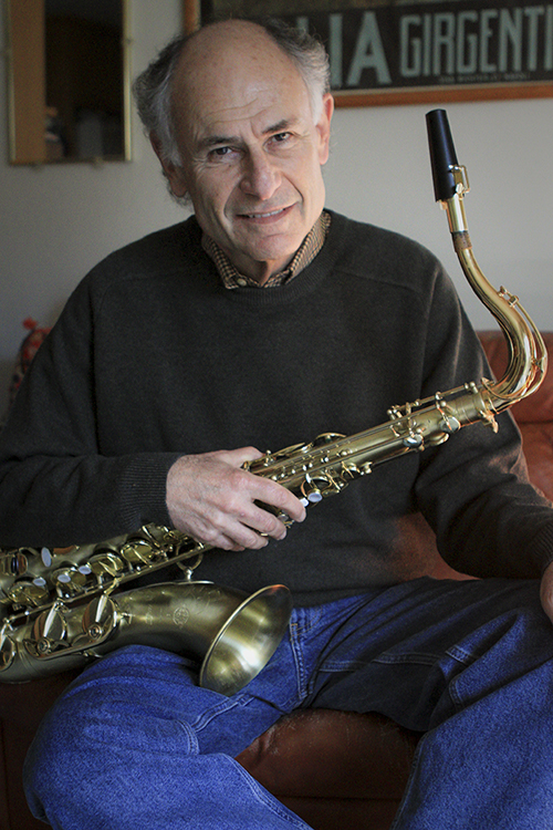 Bennett seated, holding a saxophone across his lap