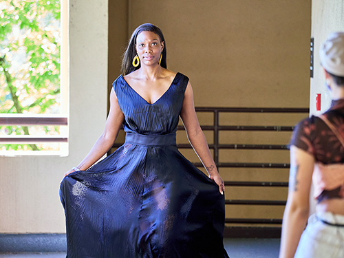 Model in dark blue, burnout, V-neck gown walks the runway